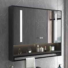 a bathroom with a sink, mirror and towel dispenser