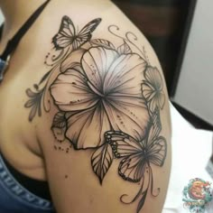 a woman's shoulder with flowers and butterflies on the back of her body,