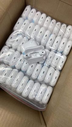 a cardboard box filled with white nintendo wii controllers