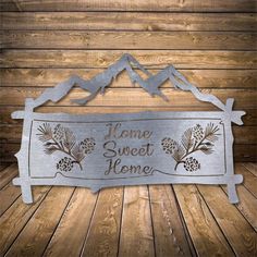 a metal sign that says, home sweet home on the side of a wooden wall