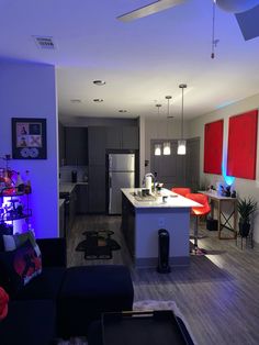 a living room filled with furniture next to a kitchen