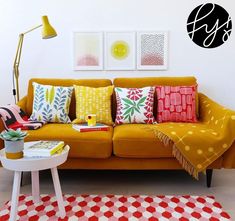 a living room filled with furniture and pillows on top of a red checkered rug