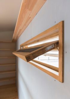 a wooden shelf mounted to the side of a wall with a pair of scissors hanging from it