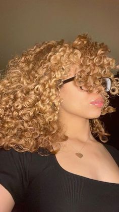 a close up of a person with curly hair and eyeglasses on her face