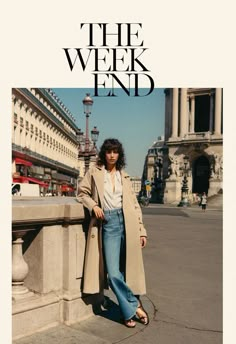 a woman leaning against a wall in front of a building with the words the week end on it