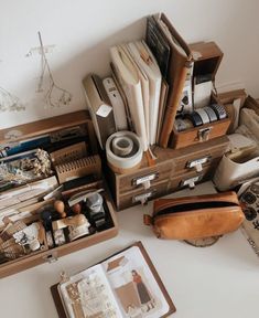 an assortment of office supplies sitting on top of a white table next to a purse