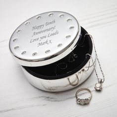 a couple of wedding rings sitting inside of a silver box on top of a table