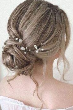 a woman with blonde hair and flowers in her hair is wearing a white dress, while she