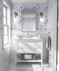 a bathroom with blue and white wallpaper, two sinks and a large mirror on the wall