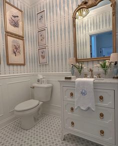 a bathroom with a sink, toilet and mirror in it's centerpieces