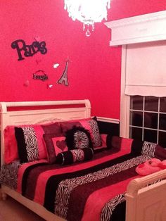 a bedroom decorated in pink and black with zebra print bedding, chandelier and window