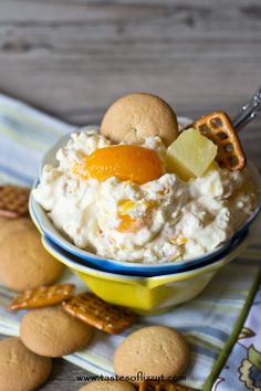 a bowl filled with food sitting on top of a table next to cookies and crackers