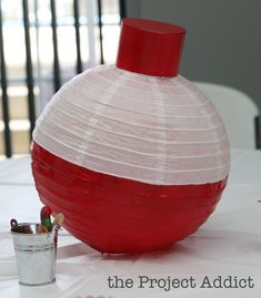 a red and white vase sitting on top of a table