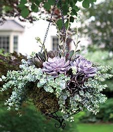 a bunch of flowers that are in a vase on a table outside by some bushes