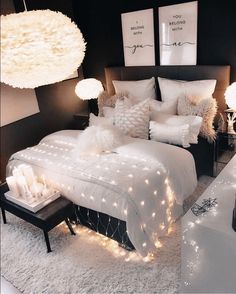 a bed with white sheets and lights on it in a room that is decorated for christmas