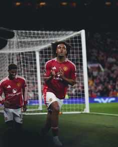 two soccer players are running towards the goal