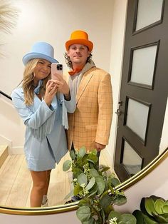 a man and woman taking a selfie in front of a mirror on the stairs