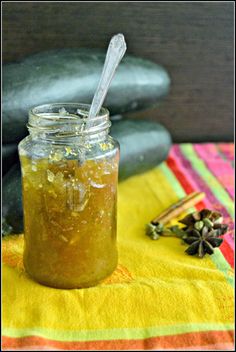 a jar filled with liquid sitting on top of a yellow table cloth next to rocks