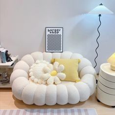 a white couch sitting on top of a wooden floor next to a lamp and table