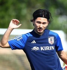 a soccer player is holding his hand up in the air while wearing a blue uniform