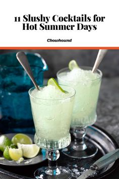 two glasses filled with ice and limes sitting on top of a metal platter