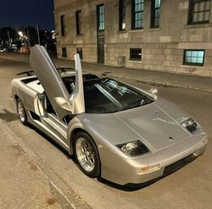 a silver sports car parked in front of a building