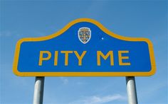 a blue and yellow sign that says pitty me on it's side in front of a blue sky