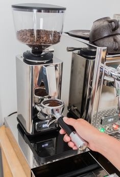 a person is using a coffee maker to make espresso