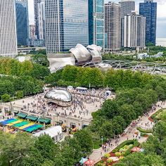 an aerial view of a park with lots of trees and people walking around it in the city