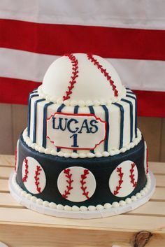 a baseball themed cake with the name lucas 1 on it and two balls in front of an american flag