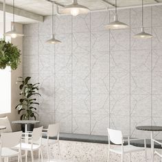 an empty restaurant with tables and chairs next to a potted plant on the wall