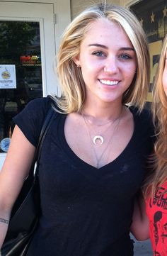 two beautiful young women standing next to each other in front of a storefront door