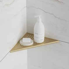 a bathroom shelf with a soap dispenser and toiletries on it in front of a marble wall