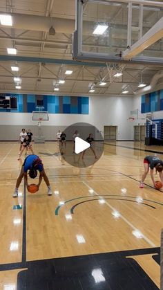 some people are playing basketball in an indoor gym with mirrors on the wall and floor