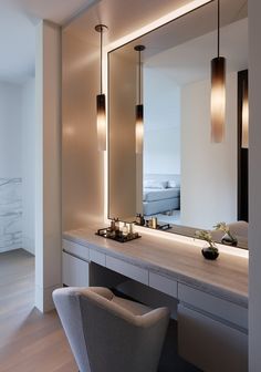 a large mirror sitting above a bathroom sink next to a counter with lights on it