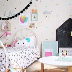 a child's bedroom decorated in pastel colors with polka dots and rainbows