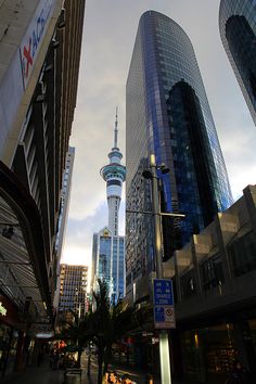 the sky is very cloudy and there are many tall buildings in the city that line this street