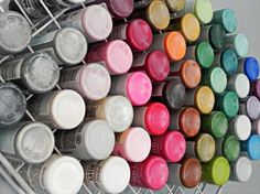 many different colors of paint are lined up on a rack