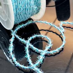 a spool of blue yarn sitting on top of a table