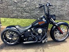 a black motorcycle parked in front of a brick wall