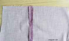 two pieces of fabric sitting next to each other on a wooden table with scissors and thread