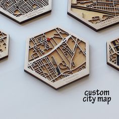 four wooden coasters that are shaped like hexagons with city maps on them