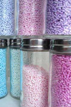 several glass jars filled with different colored candies