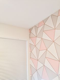 a bathroom with pink and white geometric wallpaper