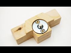 two screws are placed on top of some wooden blocks with holes in them and one is turned upside down