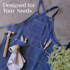 a blue apron with tools on it next to a potted plant and gardening implements