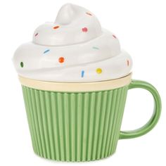 a green cup with white frosting and sprinkles on the top is sitting in front of a white background