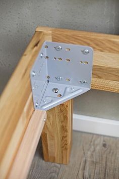 a wooden bench with metal brackets attached to it