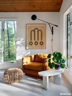 a living room filled with furniture next to a window and a painting on the wall