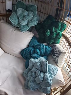 a wicker bed with several pillows and blankets on top of it, all in different colors